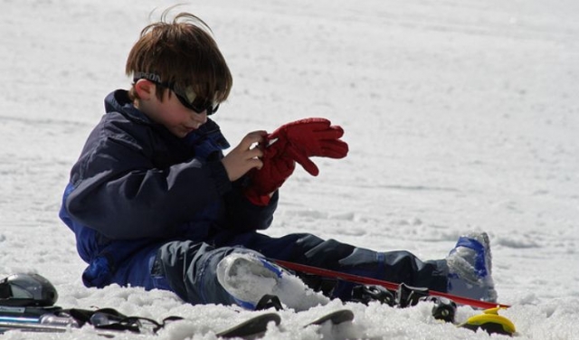  ragazzo che tocca un guanto nella neve